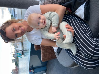 Stephanie Sidwell, founder of Sea to Sky Nannies, smiling and holding a young child by the waterfront